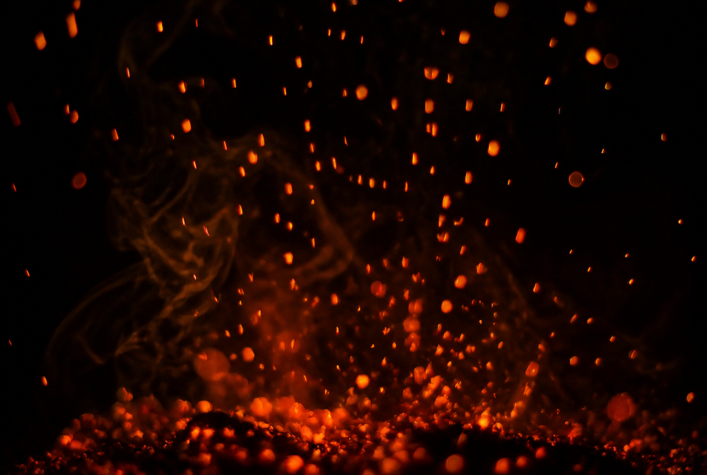 Embers rising through darkness above the roast